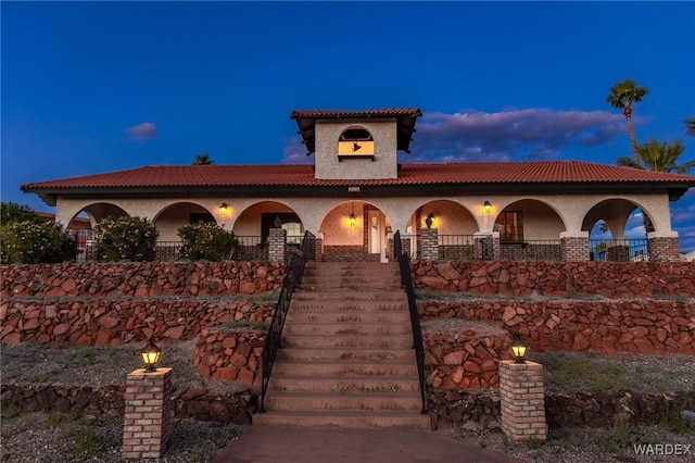 mediterranean / spanish-style home with stucco siding and a tiled roof