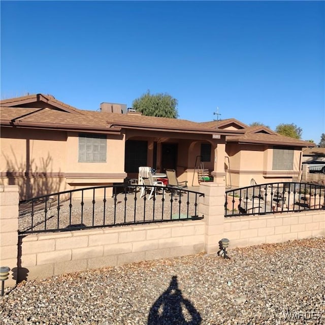 view of front of home featuring a fenced front yard and stucco siding