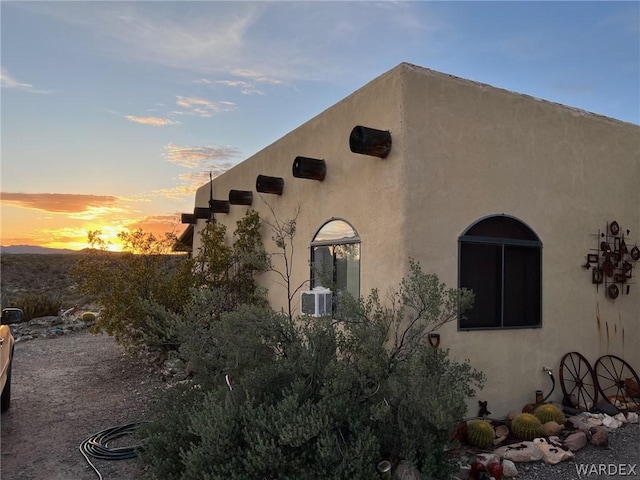 property exterior at dusk with stucco siding