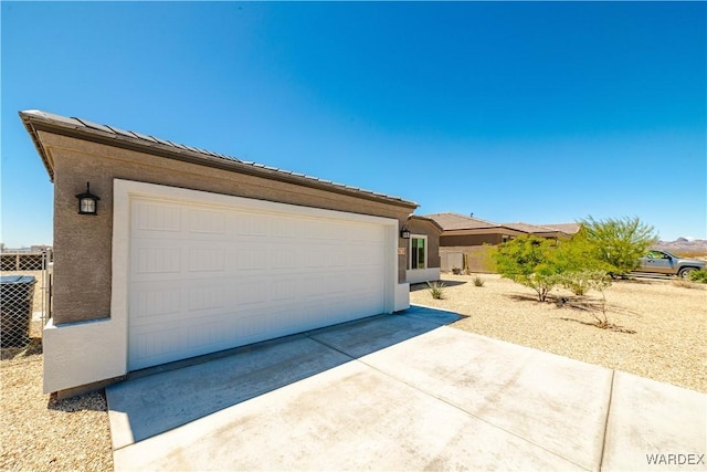 view of front of property with a garage, stucco siding, fence, and central AC unit