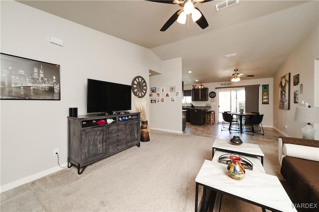 living area featuring visible vents, lofted ceiling, baseboards, ceiling fan, and light colored carpet