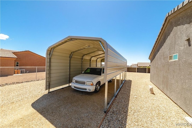 view of parking / parking lot featuring fence, a detached carport, and driveway