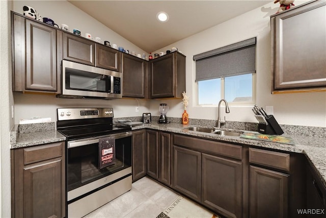 kitchen featuring dark brown cabinetry, light tile patterned flooring, recessed lighting, a sink, and appliances with stainless steel finishes