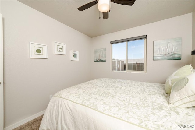 carpeted bedroom featuring baseboards and a ceiling fan