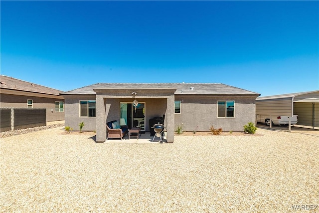 back of property featuring fence, outdoor lounge area, and stucco siding