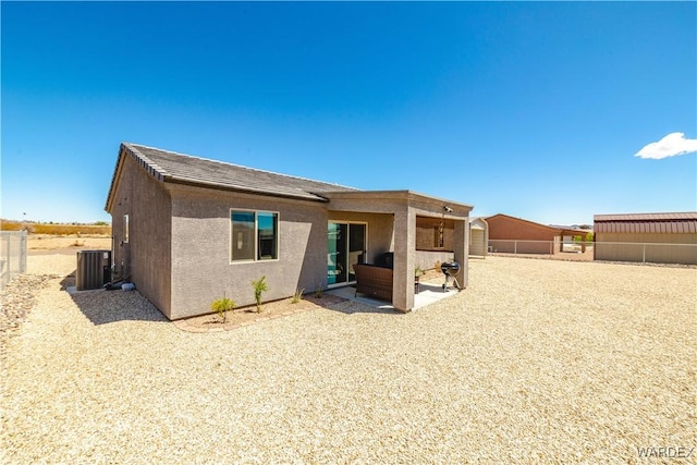 back of house with central AC, stucco siding, a patio, and fence