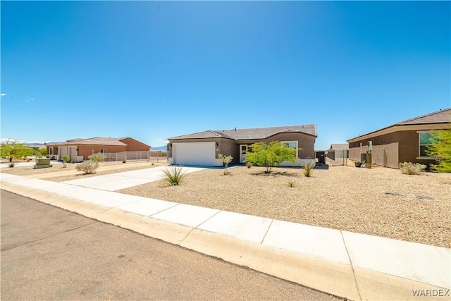 single story home featuring fence, an attached garage, concrete driveway, and stucco siding