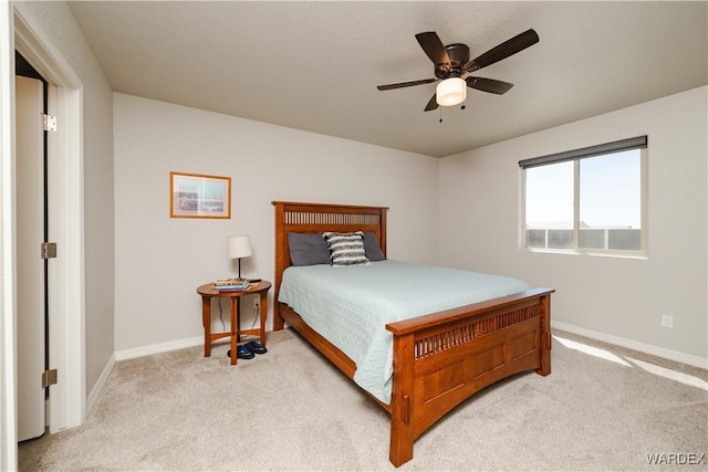 bedroom with baseboards, ceiling fan, and light colored carpet