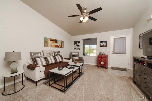 living area featuring baseboards, a ceiling fan, lofted ceiling, and light carpet