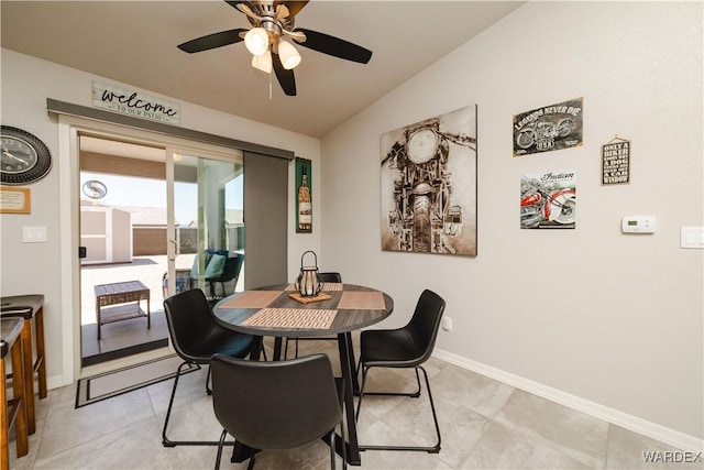dining space featuring light tile patterned floors, ceiling fan, vaulted ceiling, and baseboards