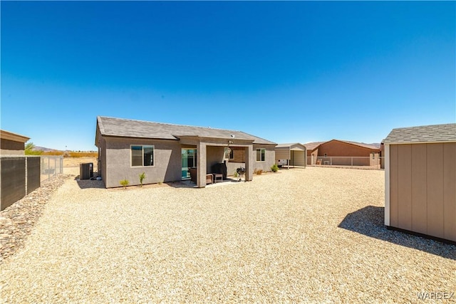 rear view of property featuring central AC and fence