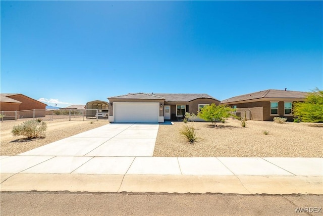view of front facade with concrete driveway, stucco siding, fence, and a garage