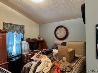 bedroom with vaulted ceiling and a textured ceiling