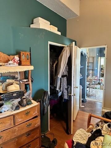 bedroom with a high ceiling, dark wood-style floors, and a closet