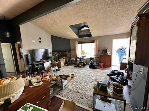 living area with a fireplace, a textured ceiling, and lofted ceiling with beams