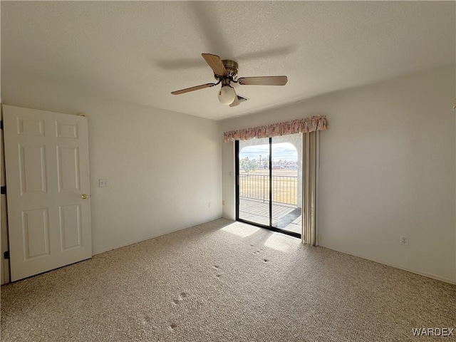 empty room featuring carpet floors, ceiling fan, and a textured ceiling