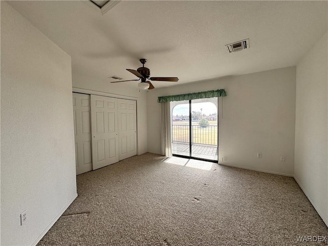 unfurnished bedroom featuring carpet, a closet, visible vents, a ceiling fan, and access to outside