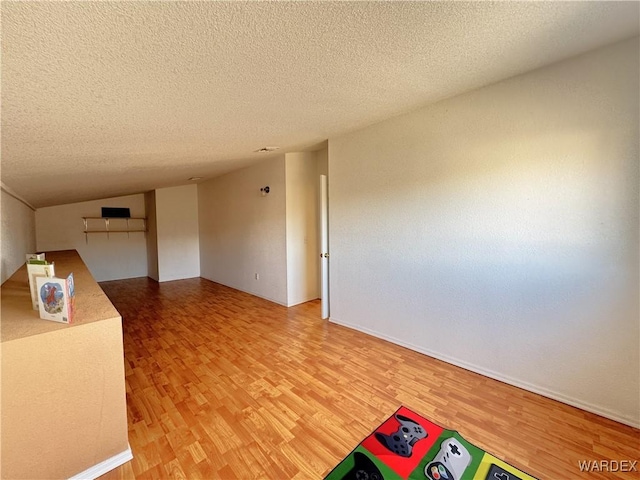 empty room featuring a textured ceiling and wood finished floors