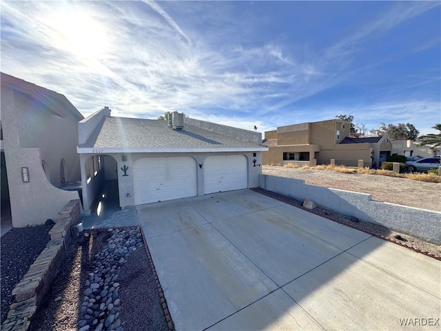 view of front of property featuring an attached garage, concrete driveway, and stucco siding