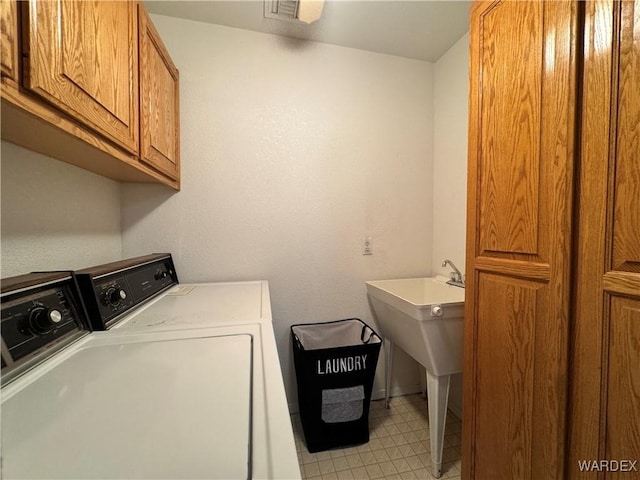 laundry area featuring washer and dryer, cabinet space, and visible vents