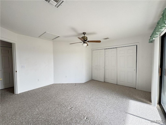 unfurnished bedroom with a ceiling fan, a closet, visible vents, and attic access