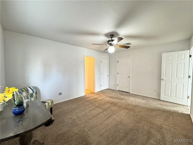 unfurnished bedroom featuring carpet floors, visible vents, baseboards, and a ceiling fan