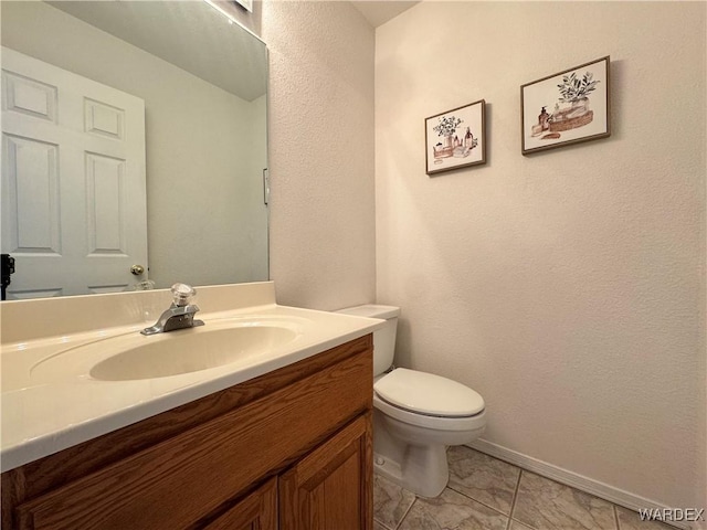 half bath featuring vanity and toilet