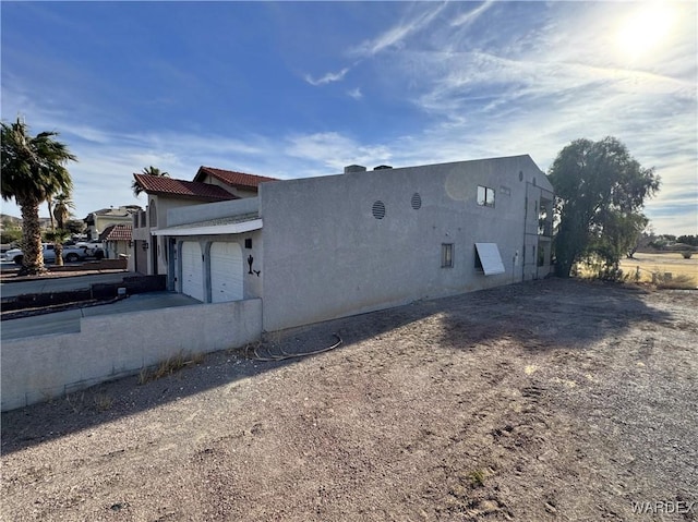 view of property exterior featuring a garage, driveway, and stucco siding