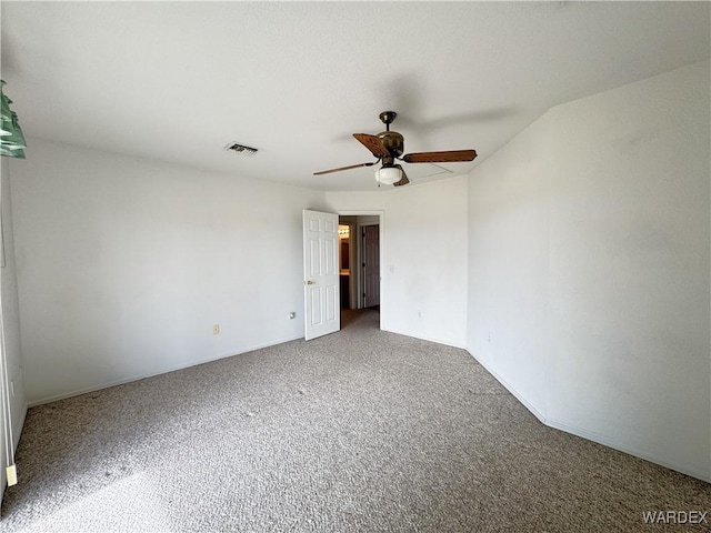 carpeted spare room featuring visible vents and a ceiling fan