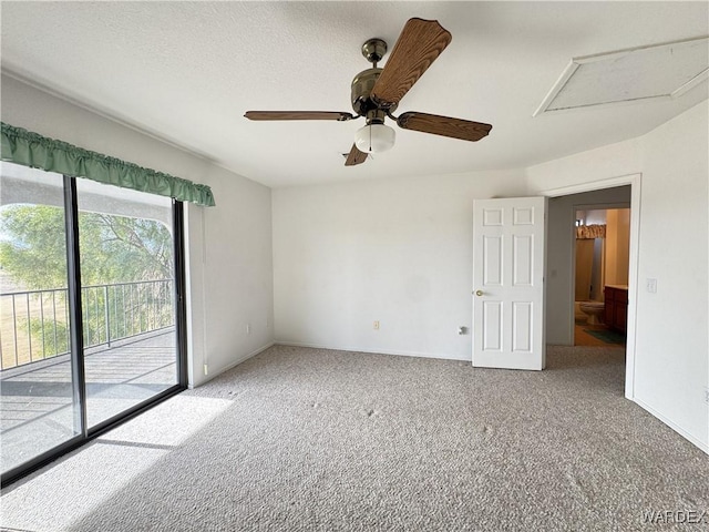 carpeted spare room featuring attic access, a textured ceiling, and baseboards