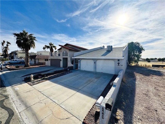 view of front of property featuring an attached garage, cooling unit, concrete driveway, and stucco siding