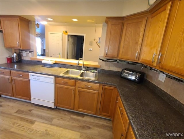 kitchen with a sink, brown cabinetry, and dishwasher