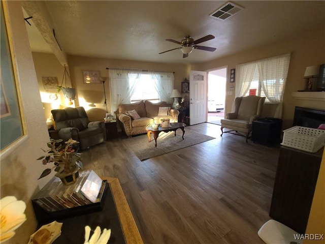 living room featuring ceiling fan, dark wood-style flooring, and visible vents