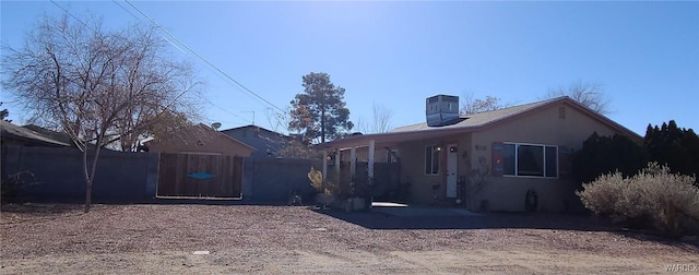 exterior space with central air condition unit, fence, and stucco siding