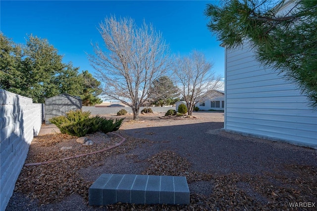 view of yard featuring a shed, an outdoor structure, and a fenced backyard