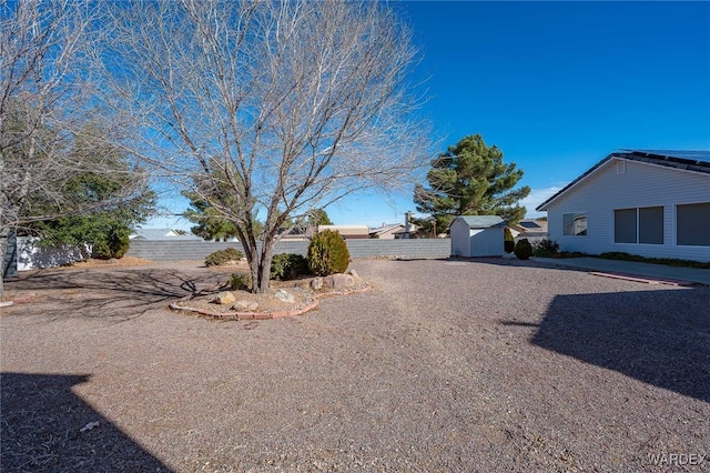 view of yard with a shed, fence, and an outdoor structure