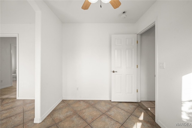 unfurnished room with baseboards and a ceiling fan