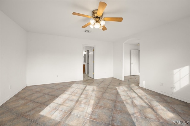 unfurnished room with arched walkways, baseboards, visible vents, and a ceiling fan