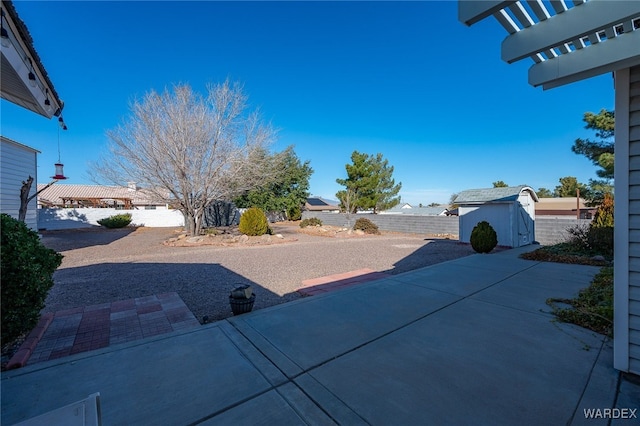 view of yard featuring a shed, a patio, a fenced backyard, and an outdoor structure