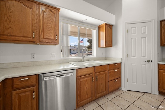 kitchen with dishwasher, light countertops, brown cabinetry, and a sink