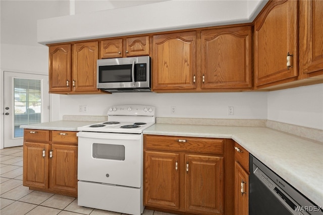 kitchen featuring white electric range oven, dishwasher, stainless steel microwave, brown cabinets, and light countertops