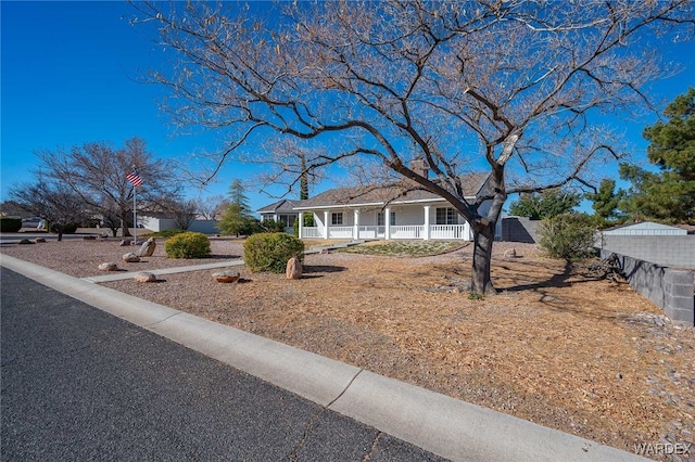 view of front facade featuring covered porch and fence