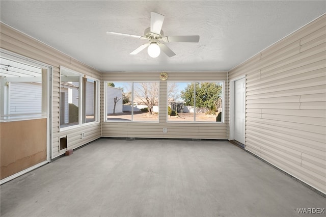 unfurnished sunroom with ceiling fan