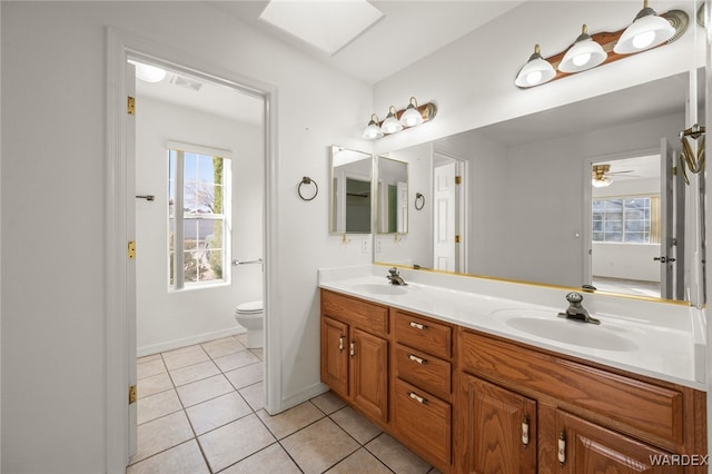 full bathroom with a healthy amount of sunlight, a skylight, and a sink