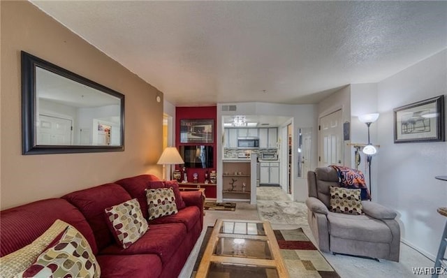 living room with visible vents and a textured ceiling