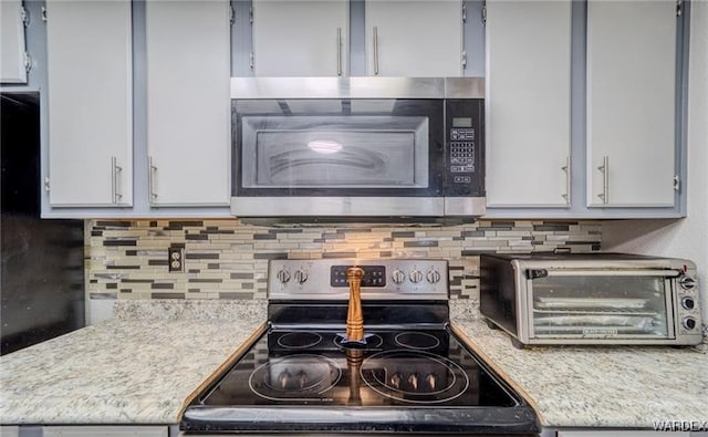 kitchen featuring light countertops, appliances with stainless steel finishes, and tasteful backsplash