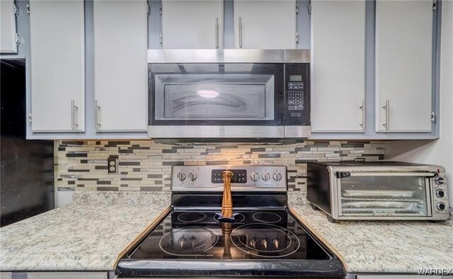 kitchen featuring light countertops, appliances with stainless steel finishes, and tasteful backsplash