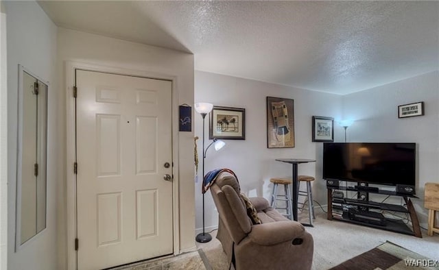 foyer entrance featuring light carpet, a textured ceiling, and baseboards