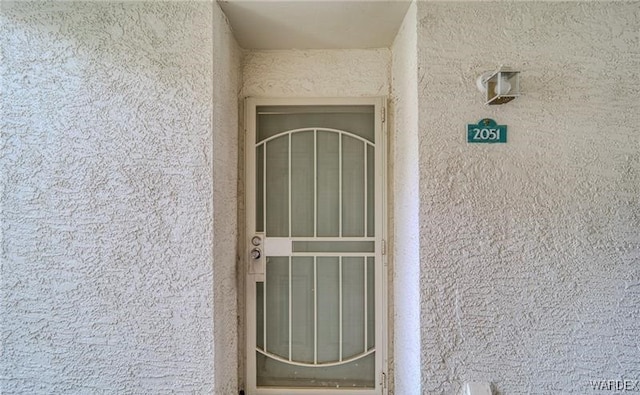 doorway to property featuring stucco siding