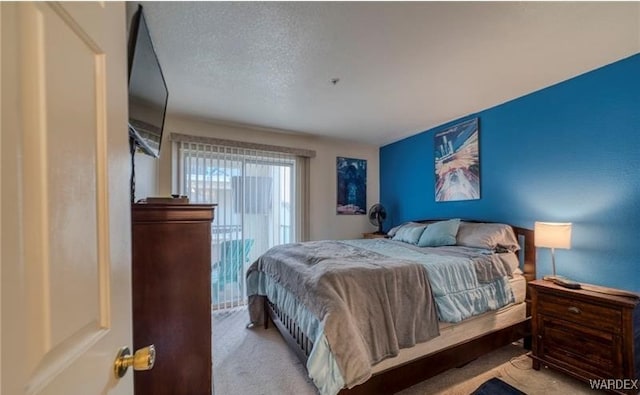 bedroom featuring light colored carpet and a textured ceiling